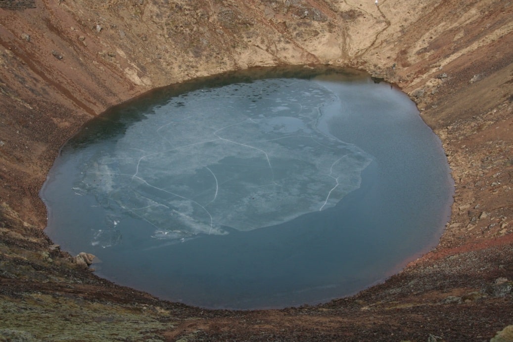 На дне кратера скопилась вода, образовав миниатюрное озеро