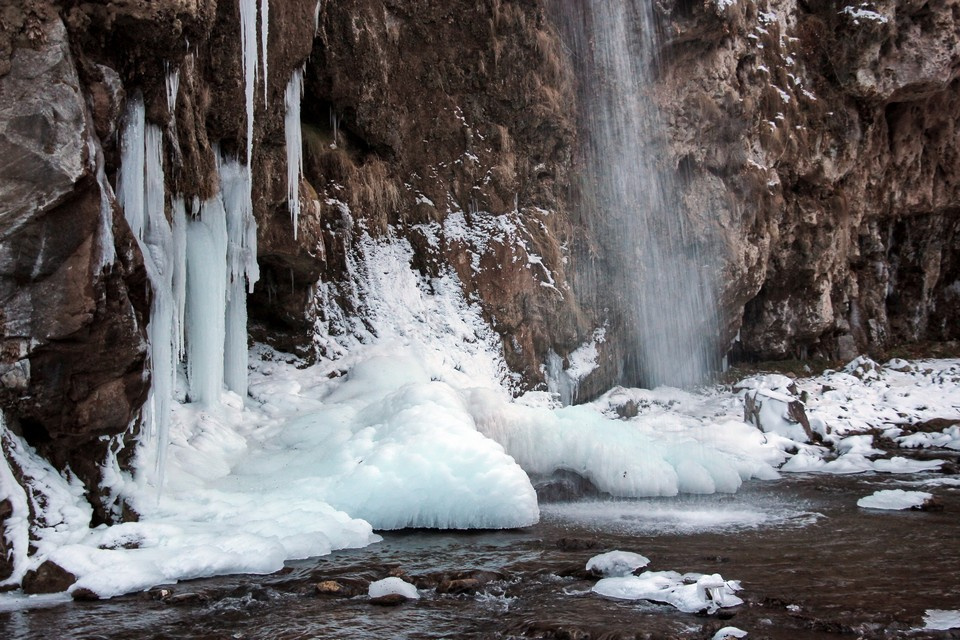 Зимой струи водопада замерзают, превращаясь в ледяные сталактиты